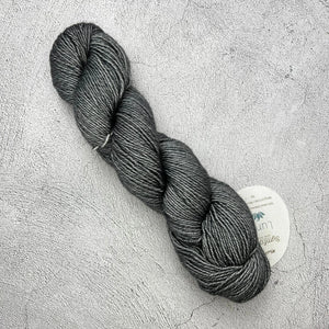 A skein of Symfonie Luna grey yarn on a concrete surface. (Brand: Knit Pro)