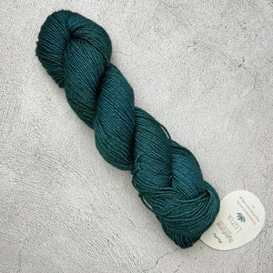 A skein of Knit Pro Symfonie Luna yarn on a grey surface.